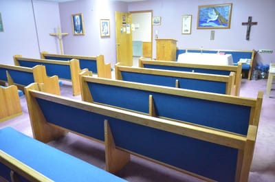 Interior view of a quiet chapel with wooden pews