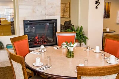 Bright dining room with a fireplace and table setting