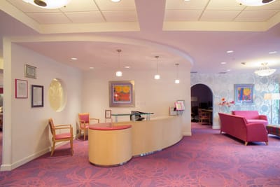 Bright lobby area with pink decor and seating