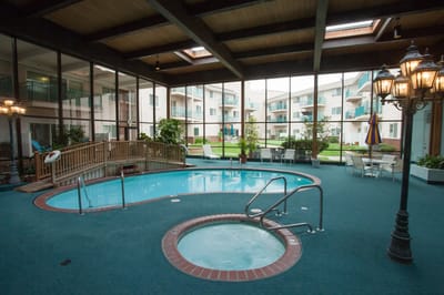 Indoor swimming pool area with spa and seating