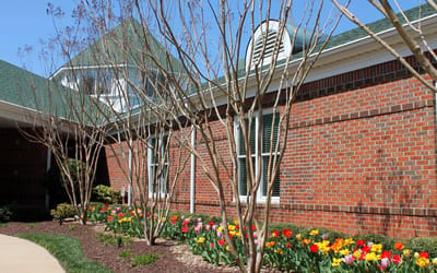 Exterior view of facility with blooming flowers and trees