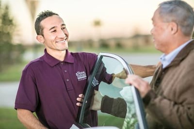 A caregiver assisting a senior at a vehicle