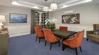 A well-decorated dining room with orange chairs