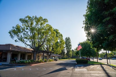 Exterior view of Park Visalia Assisted Living facility with trees
