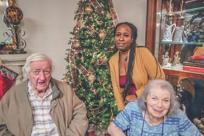Residents and staff near a festive Christmas tree