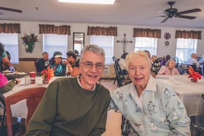 Two seniors posing happily in a common area