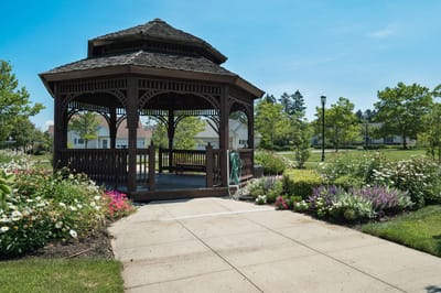 Outdoor gazebo surrounded by flowers and greenery