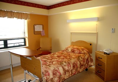 Cozy resident room with bed and chair