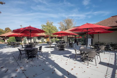 Outdoor seating area with red umbrellas and tables