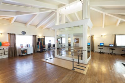 Rehabilitation room with ballet bar and exercise equipment