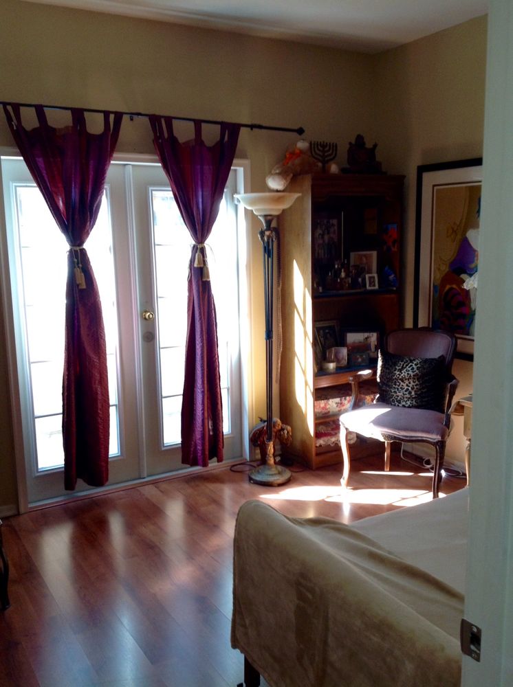 A cozy resident room with sunlight streaming through curtains