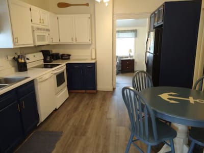A bright kitchen area with blue cabinets and table