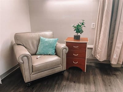 Cozy corner of a resident's room with a chair and table