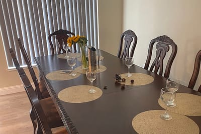 Dining room set for a meal with glasses and flowers