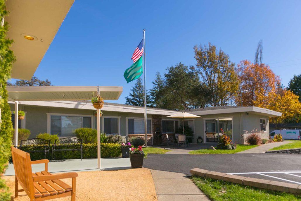 Exterior view of Summerfield Healthcare Center with flags and seating area
