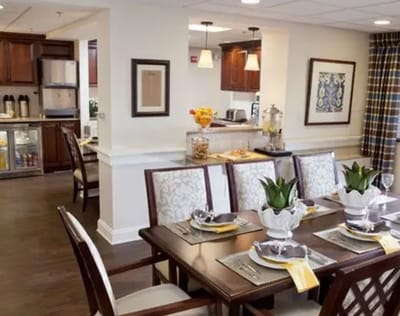 Interior dining room with a well-set table and kitchen area