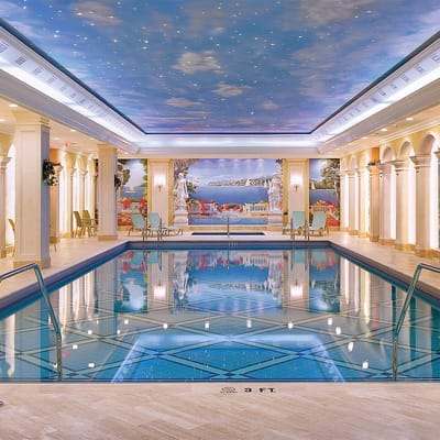 Indoor pool area with decorative ceiling and mural