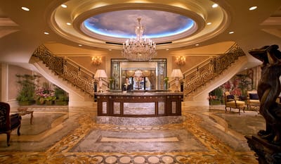 Luxurious lobby interior with grand staircase and chandelier