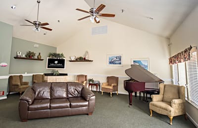 Common area with seating and piano in a senior living facility