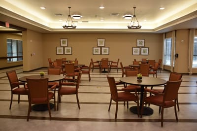 Common area with tables and chairs in a senior living facility