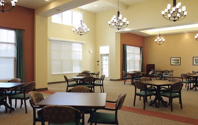 Interior view of a bright common area with tables and chairs