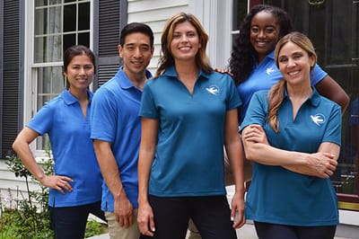 Staff members posing together outdoors in facility uniforms