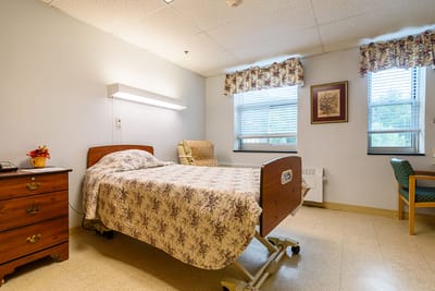 Cozy resident room with bed and chair