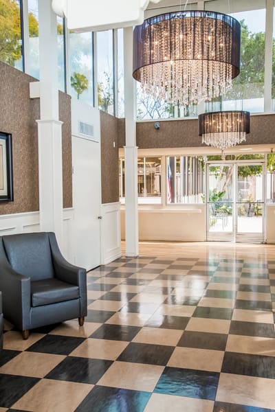 Bright lobby area with elegant chandeliers and seating