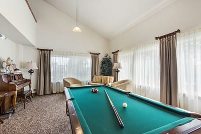 Interior game room with a pool table and seating