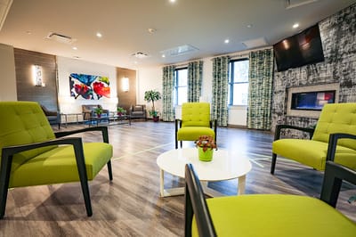 Bright common area with green seating and artwork