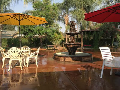 Outdoor patio area with a fountain and umbrellas