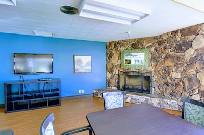 Cozy common area with a stone fireplace and TV