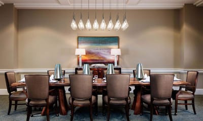 Elegant dining room with a large wooden table and hanging lights