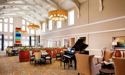Bright and inviting common area with seating and a piano