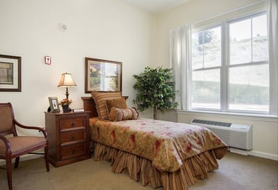 Cozy resident room with a bed and chair
