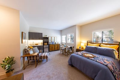 A well-furnished resident room with kitchenette