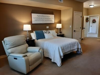 Cozy resident room with bed and recliner chair