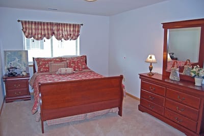 Cozy bedroom with a floral comforter and wooden furniture