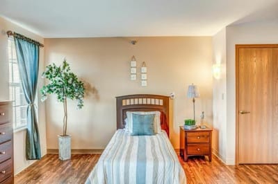 Brightly lit private resident room with a single bed