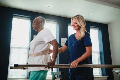 A staff member assisting a resident during therapy