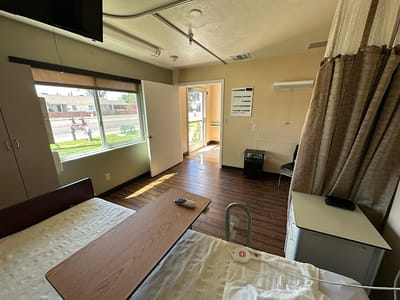 An interior view of a patient room with a bed and window