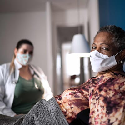 VITAS Healthcare Inpatient Hospice Unit – Texas, hospice care in Dallas, TX — Healthcare worker assisting patient in a cozy room