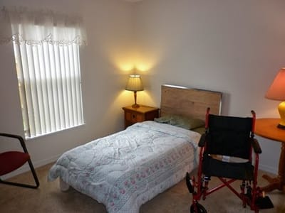 Private resident room with a bed and wheelchair