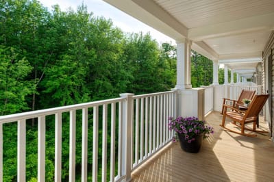 Veranda with rocking chairs overlooking a wooded area