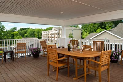 Outdoor dining area with wooden furniture and greenery