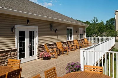 Outdoor seating area with wooden chairs and flower pots