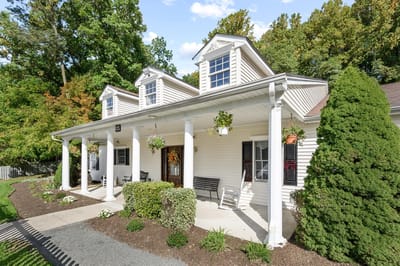 Exterior view of a residential facility with porch and garden