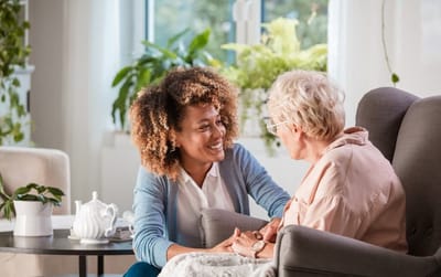Caregiver engaging with an elderly resident in a cozy setting