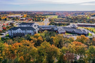 Aerial view of a senior living facility surrounded by autumn trees