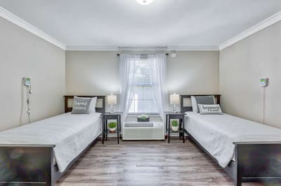 Cozy twin beds in a well-lit resident room